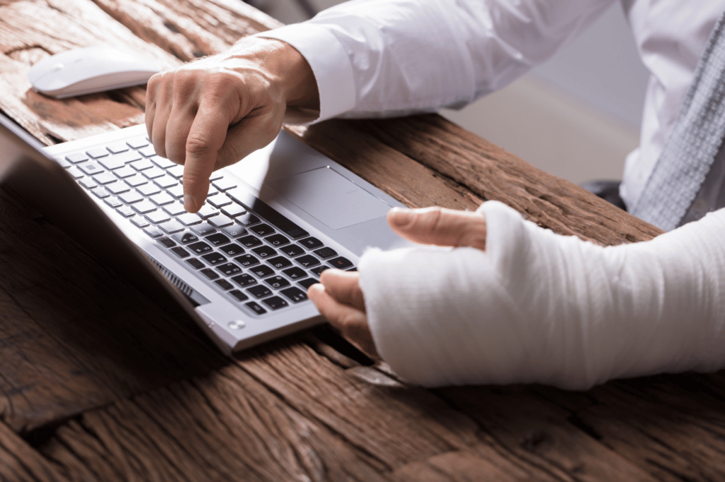 Injured man looking at laptop