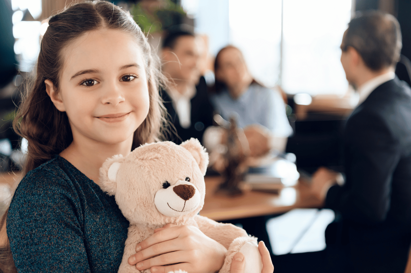 Girl with stuffed animal with guardianship attorney in background