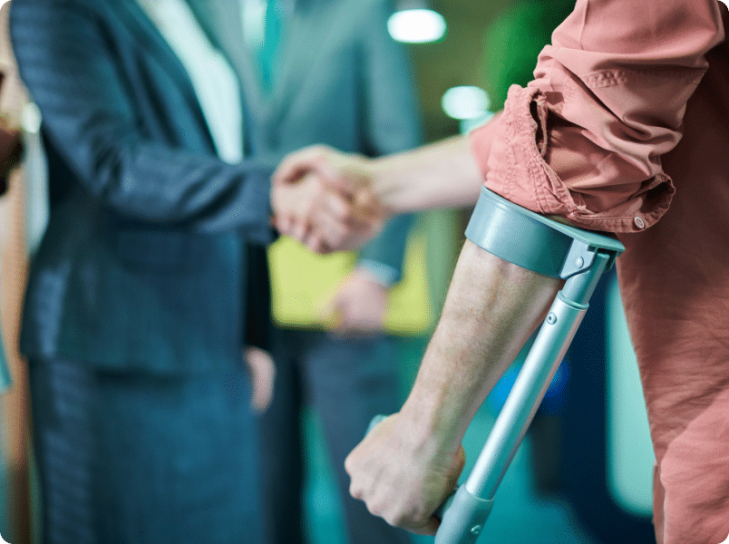 A man holding a crutch and shaking hands with a lawyer