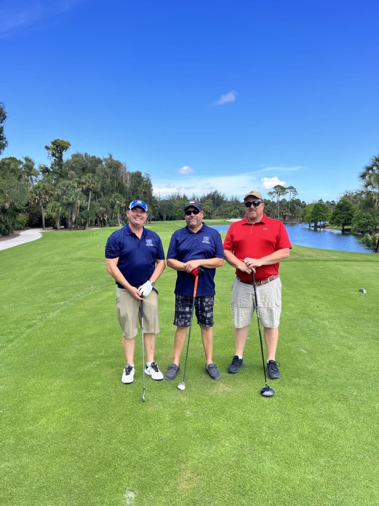 Three men standing on a golf course