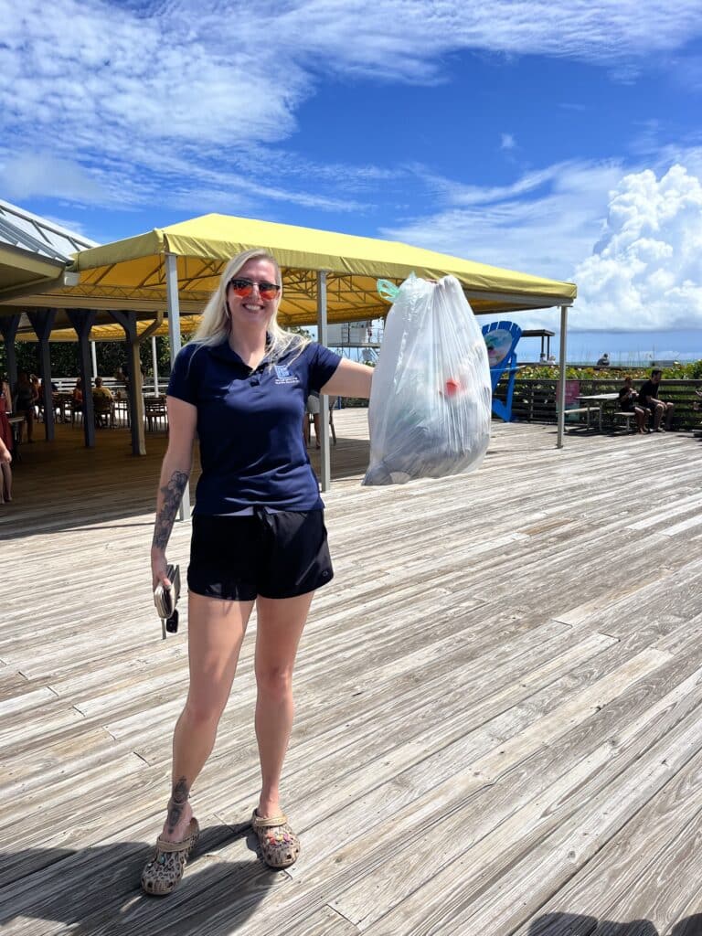 A woman holding a sack bag of plastics