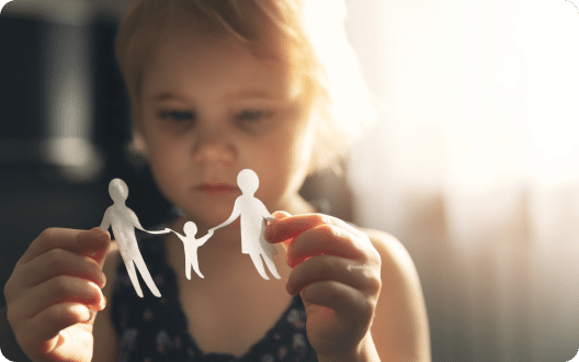 A little girl holding a paper cutout of a family