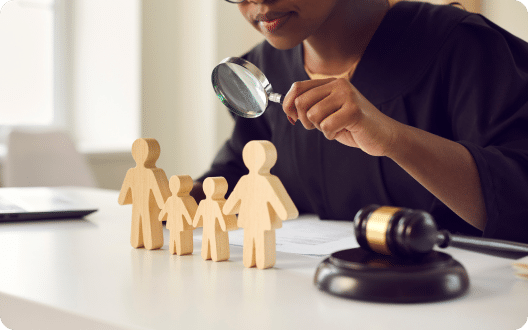 A judge with a gavel and a magnifying glass looking over a model of a family