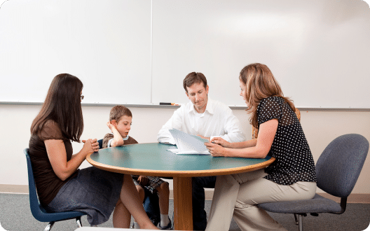 Teacher talking to parents and their child