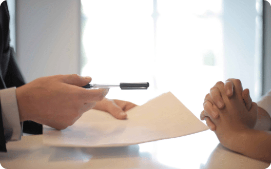 A lawyer handing over a document for a client to sign