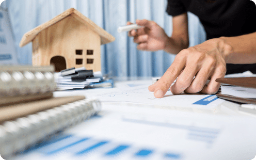 Financial documents in front of a model of a house