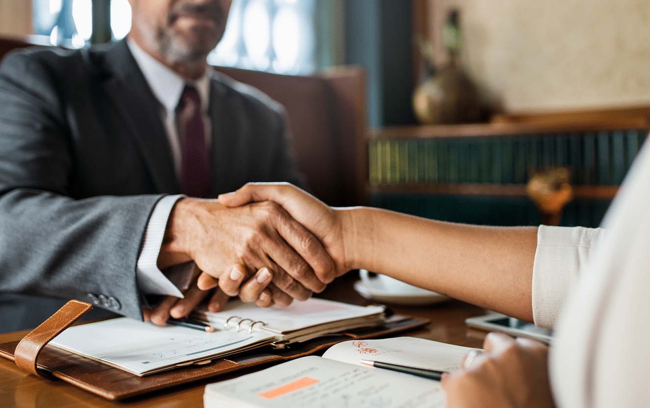 Two professionals shaking hands during a probate mediation session, representing a peaceful resolution to a dispute in Florida estate planning.